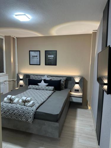 a bedroom with a bed with two lamps on it at NOA Luxury Apartment in Bitola