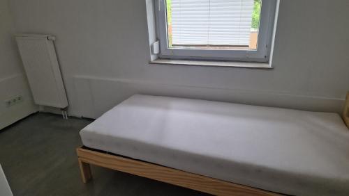 uma pequena cama num quarto com uma janela em Rooms & Apartments Schwäbisch Gmünd em Schwäbisch Gmünd