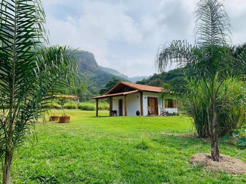 a house in the middle of a field with trees at Chale Vale das Cachoeiras in Capitólio