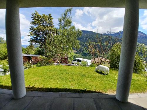 a view of a yard with a sheep laying in the grass at Ferienwohnung Witting in Wenns