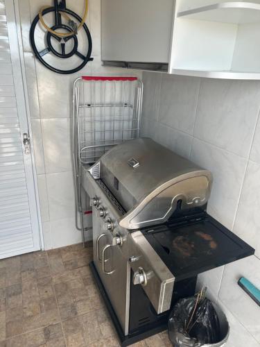 a kitchen with a grill in a kitchen at Apartamento Chique frente ao mar in Flecheiras
