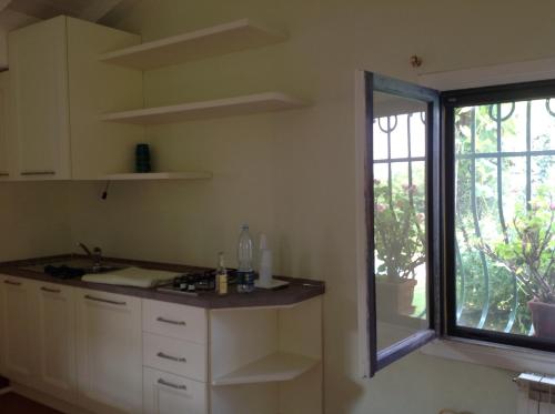 a kitchen with a sink and a window in it at Casetta in giardino con piscina in Luino