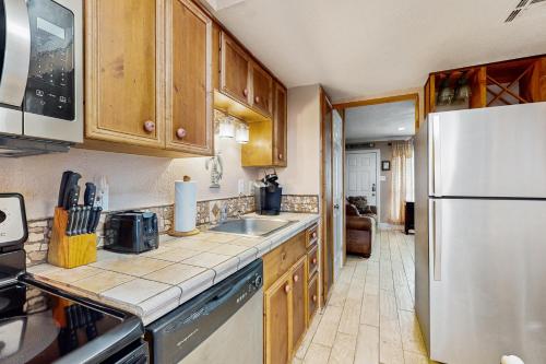 a kitchen with a sink and a refrigerator at Quaint Oasis in Padre Island