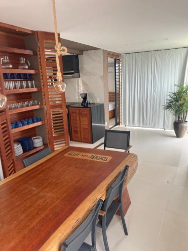 a kitchen with a wooden table in a room at Apartamento Chique frente ao mar in Flecheiras