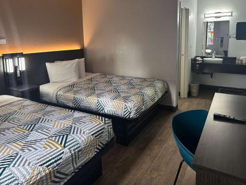 um quarto de hotel com duas camas e um lavatório em Motel 6-Kissimmee, FL - Orlando em Orlando