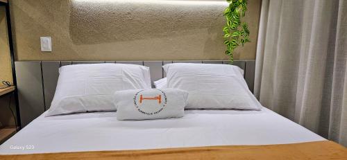a bed with white sheets and a pillow on it at Flats Tramonto - By EasyHost in João Pessoa