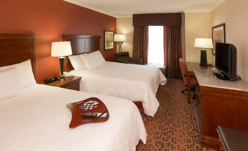 a hotel room with two beds and a flat screen tv at Hampton Inn & Suites Cleveland-Beachwood in Beachwood