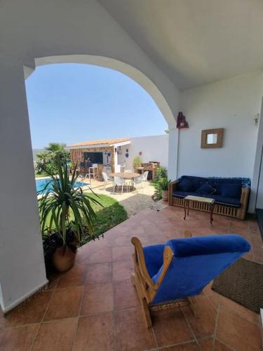 a living room with a blue chair and a patio at Villa Casa Deraoui in Tangier