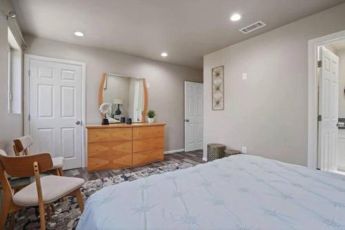 a bedroom with a bed and a dresser and a mirror at Spacious family Guesthouse private entry near six flags in Santa Clarita