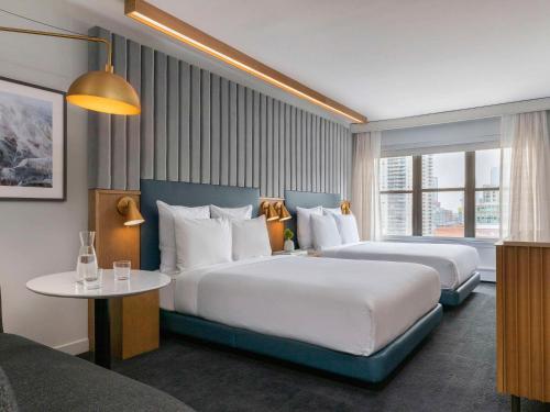 a hotel room with two beds and a table at 21c Museum Hotel Chicago in Chicago