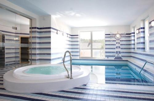 a bathroom with a tub and a swimming pool at Hotel Dakol in Petrovice u Karviné