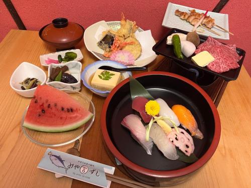 una mesa con un plato de sushi y otros alimentos en Villa KUMANO, en Hongū