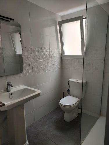 een badkamer met een toilet, een wastafel en een raam bij dama iberica II in Valencia