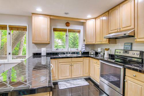 a kitchen with wooden cabinets and black counter tops at 2-Story Deck Waterfront Lake Lure Home! in Lake Lure