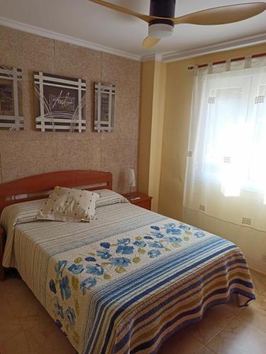 sypialnia z łóżkiem z niebieskim i żółtym kocem w obiekcie Joyitas Gandía Beach w mieście Playa de Gandia