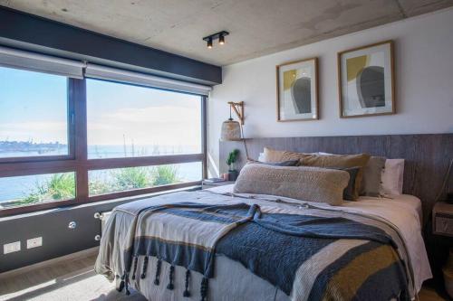 a bedroom with a bed and a large window at Departamento B vista privilegiada cerro Barón in Valparaíso