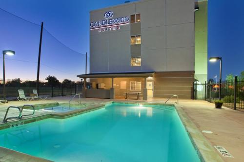 a large swimming pool in front of a building at Candlewood Suites Roswell, an IHG Hotel in Roswell