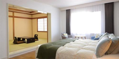 1 dormitorio con 1 cama grande y espejo grande en Izu Kogen Ocean Resort, Ito Villa-TOKI-, en Ito