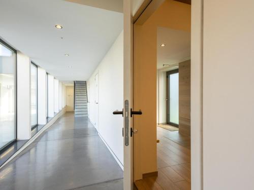 a hallway with white walls and a door and a hallway with windows at Villa Mareon in Schorisse