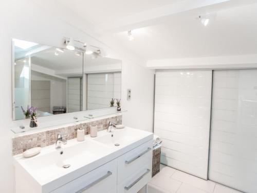 een badkamer met 2 wastafels en een grote spiegel bij La petite Sorgues in Sorgues