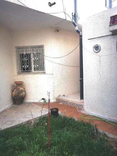 a building with a window and a plant in the yard at Tiba soliman plage in Nabeul