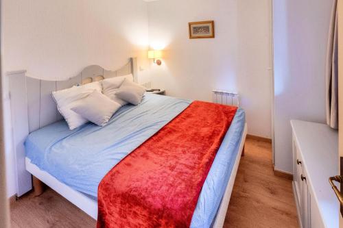 une chambre avec un lit avec une couverture rouge dessus dans l'établissement Résidence L'Alpaga - maeva Home - Appartement 2 Pièces 5 Personnes - Sélection MAE-8474, à La Salle Les Alpes