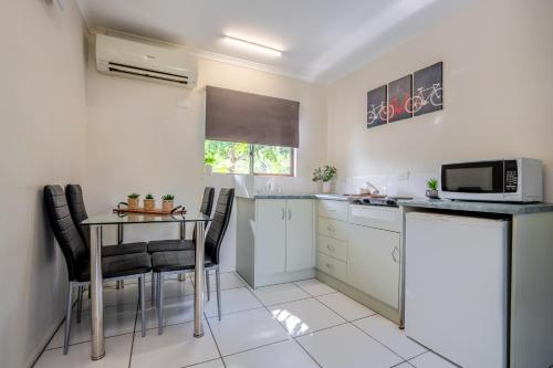 a small kitchen with a table and a microwave at Tasman Holiday Parks - Cairns Cool Waters in Cairns