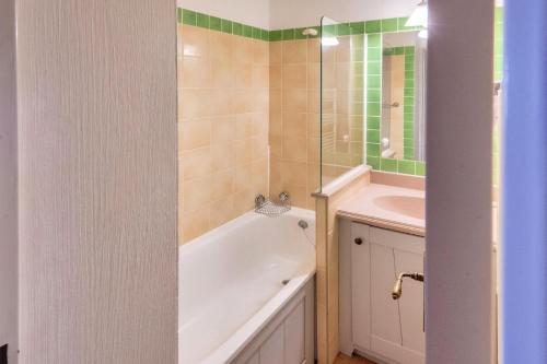 une salle de bain avec une baignoire et un lavabo dans l'établissement Résidence L'Alpaga - maeva Home - Appartement 2 Pièces 5 Personnes - Sélection MAE-8474, à La Salle Les Alpes