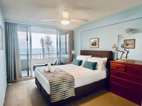 a bedroom with a bed and a large window at Park Towers Holiday Units in Gold Coast