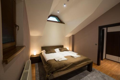 a bedroom with a bed with two towels on it at Hotel DARO in Banská Štiavnica