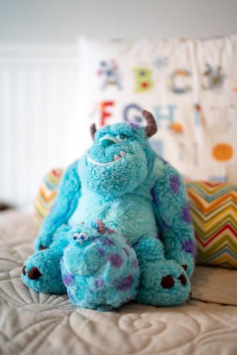 a blue teddy bear sitting on a bed at Beautiful Townhome just 8 miles from Disney in Kissimmee