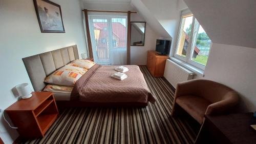 um quarto com uma cama, uma cadeira e uma janela em Akwen em Rewal