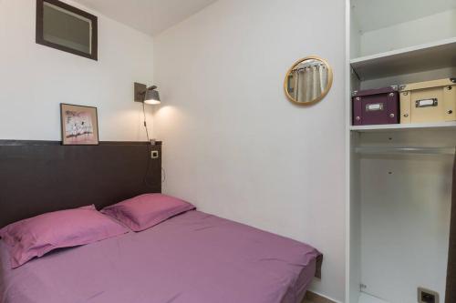 a bedroom with a purple bed and a mirror at Les Gîtes de Grand Père Jules in Violès