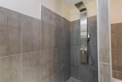 La salle de bains est pourvue d'une douche avec du carrelage brun. dans l'établissement Les Gîtes de Grand Père Jules, à Violès