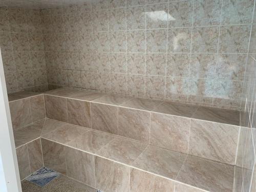 a bathroom with a shower with a tiled wall at Quinta Doña Adita in Girón