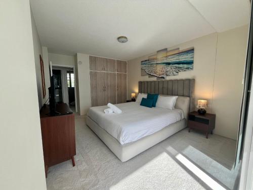 a bedroom with a white bed and a television at Park Towers-Goodwin Towers Holiday Units in Gold Coast
