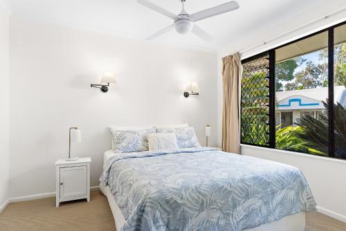 a white bedroom with a bed and a window at 1 Bedroom Ground Level Unit in Noosaville Resort in Noosaville