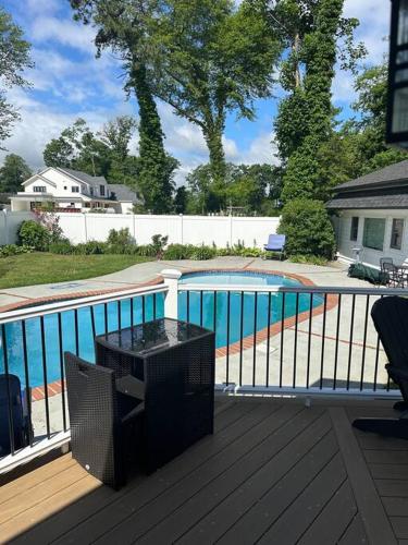 a balcony with a television and a swimming pool at The Most Desired Summer Retreat with Private Pool Just 5 Minutes from the Beach in Spring Lake