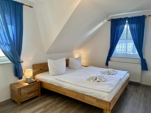 a bedroom with a large bed with blue curtains at Seehund Feriendoppelhaus "Schäferhund" in Thiessow