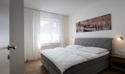 a bedroom with a bed with a picture on the wall at Ferienwohnungen Lass in Frauenkirchen