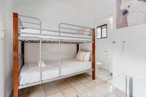 a bedroom with two bunk beds and a bathroom at Tasman Holiday Parks - Cairns Cool Waters in Cairns