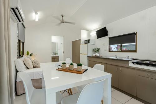 a kitchen and living room with a white table and chairs at Tasman Holiday Parks - Cairns Cool Waters in Cairns