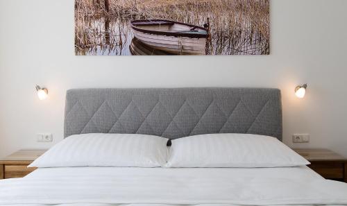 a bedroom with a bed with a painting on the wall at Ferienwohnungen Lass in Frauenkirchen