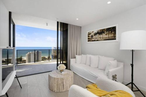 a living room with a white couch and a view of the ocean at Broadbeach Elegant apartment with views! in Gold Coast