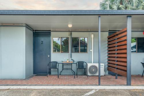 a patio with two chairs and a table in front of a house at Tasman Holiday Parks - Cairns Cool Waters in Cairns