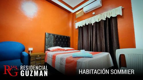 um quarto com uma cama com uma parede laranja em Residencial Guzmán 1 em Yacuiba