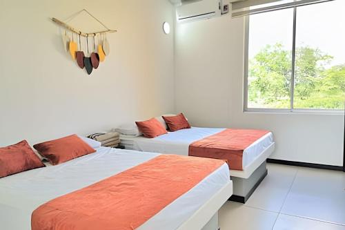 a bedroom with two beds and a window at Excepcional CASA FINCA piscina privada wi-fi tv in Tocaima