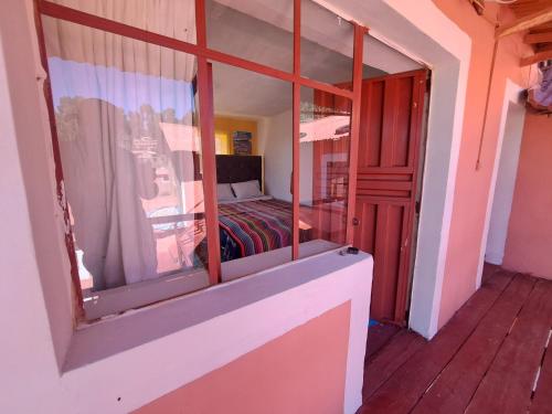 um quarto com uma janela com uma cama em kawsay Wasi Lodge De Oswaldo Cari em Ocosuyo