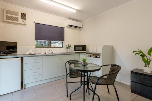 a kitchen with a table and chairs in a room at Tasman Holiday Parks - Cairns Cool Waters in Cairns