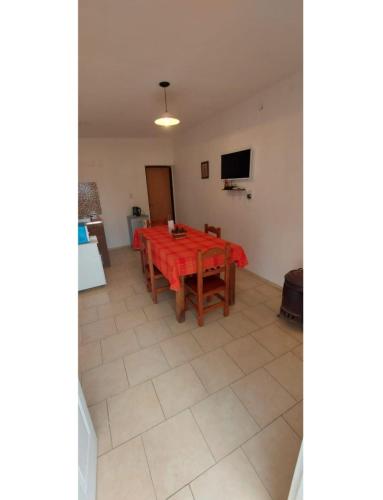 Un comedor con una mesa y un televisor. en Raíces Diaguitas II, en Vinchina
